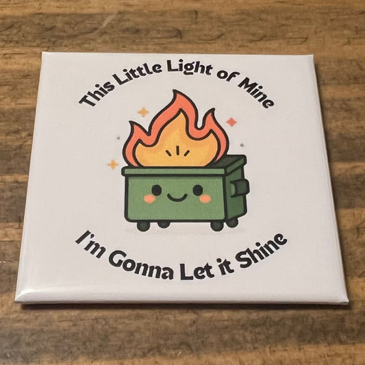 Square magnet with a cartoon fire and text on a wooden surface
